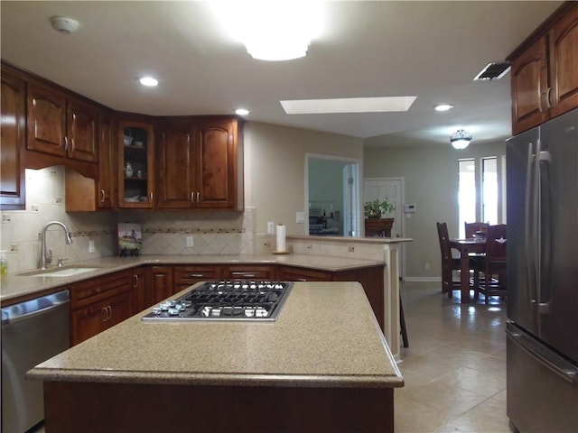 425 Seco Dr, Portland, TX 78374 - kitchen featuring stainless steel appliances, a skylight, tasteful backsplash, a center island, and recessed lighting