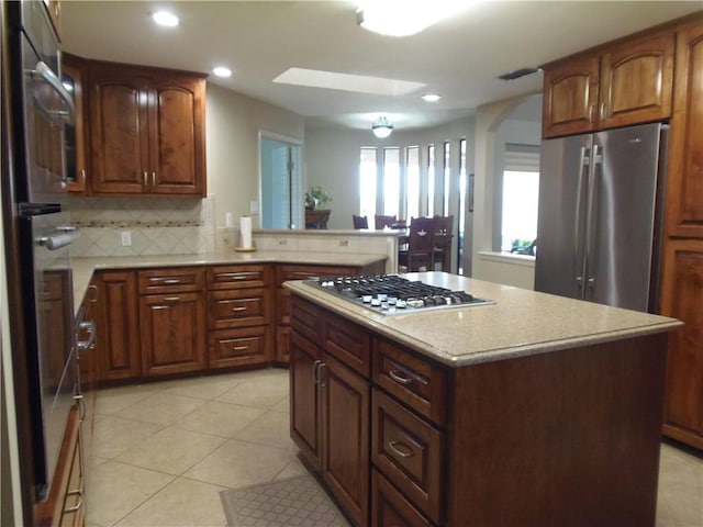 425 Seco Dr, Portland, TX 78374 - kitchen with appliances with stainless steel finishes, tasteful backsplash, arched walkways, recessed lighting, and a center island