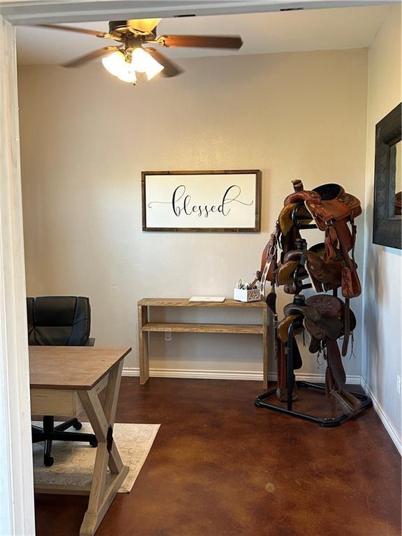 office space featuring ceiling fan and baseboards