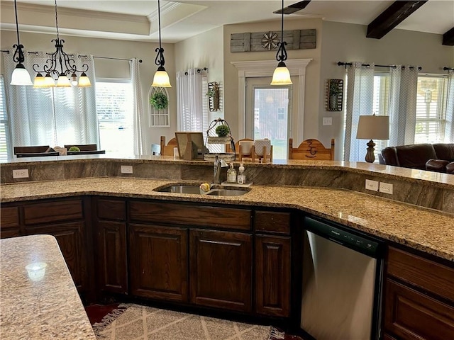 kitchen featuring a sink, light stone counters, dishwasher, and decorative light fixtures