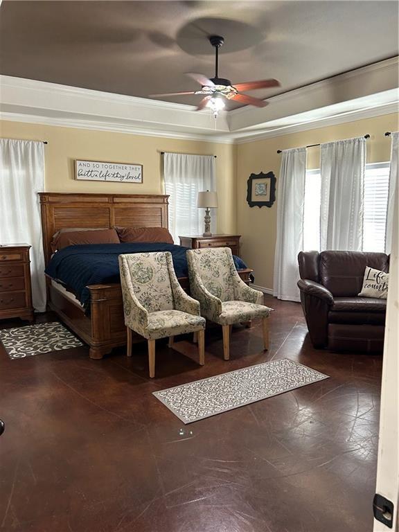 bedroom with a tray ceiling, a ceiling fan, and crown molding