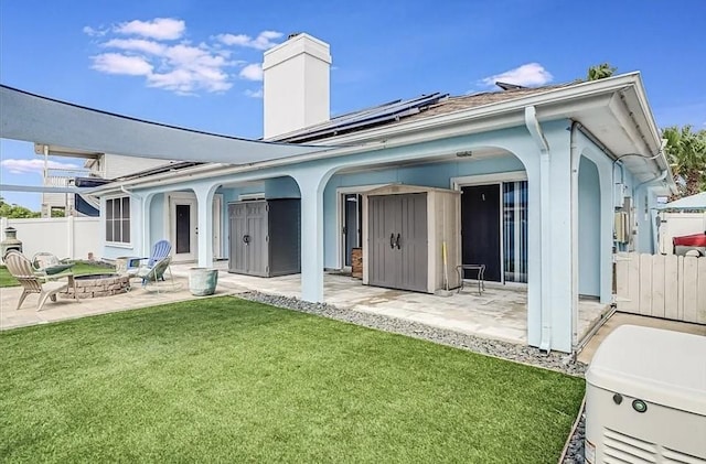 14877 Cobo De Bara, Corpus Christi, TX 78418 - back of property with a fire pit, a patio, roof mounted solar panels, and a chimney