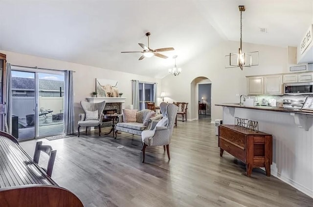 14877 Cobo De Bara, Corpus Christi, TX 78418 - living room with a chandelier, ceiling fan, arched walkways, light wood-style floors, and high vaulted ceiling