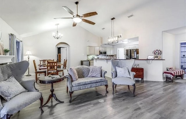 14877 Cobo De Bara, Corpus Christi, TX 78418 - living room featuring ceiling fan, a chandelier, wood finished floors, arched walkways, and high vaulted ceiling