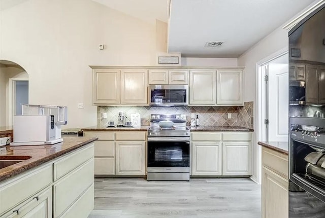 14877 Cobo De Bara, Corpus Christi, TX 78418 - kitchen featuring stainless steel appliances, light wood-style floors, backsplash, and dark stone counters