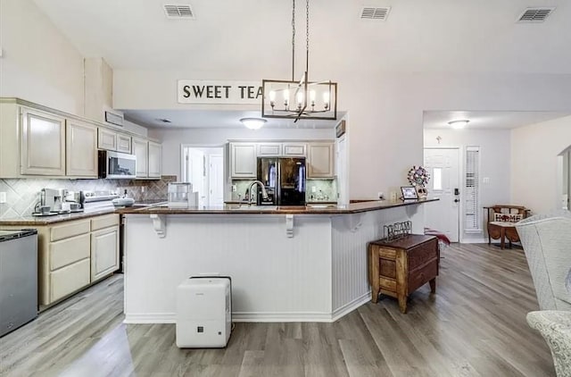 14877 Cobo De Bara, Corpus Christi, TX 78418 - kitchen featuring stainless steel microwave, smart refrigerator, a breakfast bar area, and light wood-type flooring