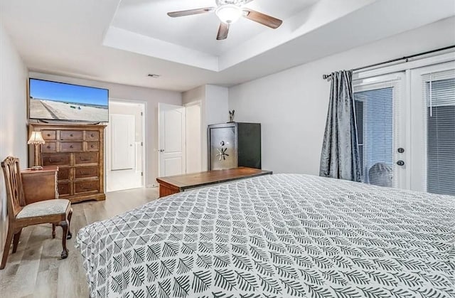14877 Cobo De Bara, Corpus Christi, TX 78418 - bedroom featuring light wood-type flooring, a tray ceiling, and a ceiling fan