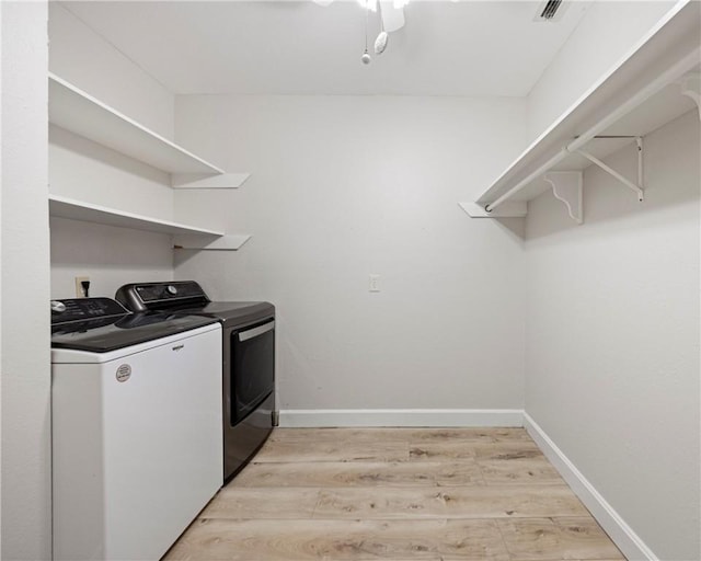 laundry room with light wood-style floors, baseboards, separate washer and dryer, and laundry area