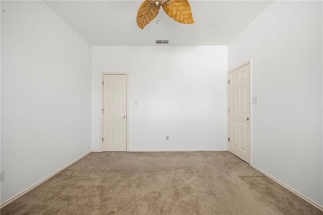 carpeted spare room with visible vents and ceiling fan