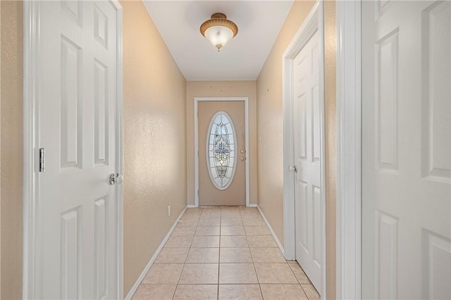 doorway to outside with light tile patterned floors and baseboards