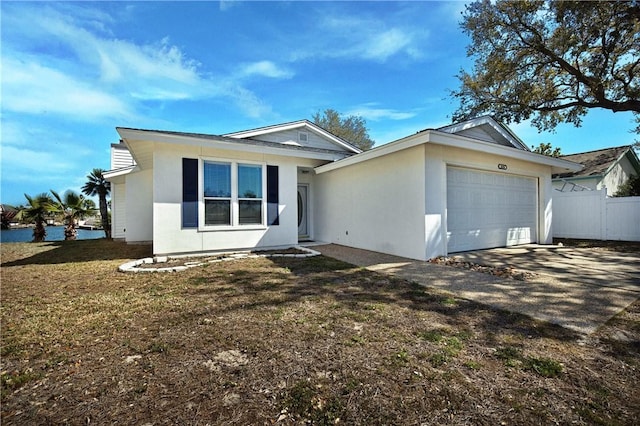 ranch-style house featuring fence, concrete driveway, a front yard, stucco siding, and an attached garage