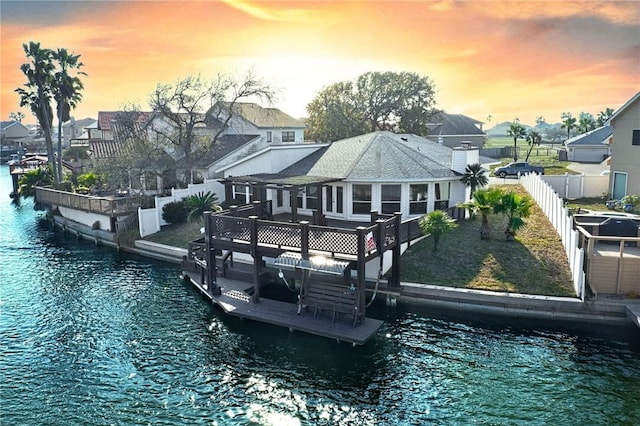 exterior space featuring a residential view, a water view, and fence