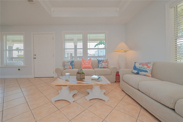 living room with ornamental molding, plenty of natural light, light tile patterned floors, and a tray ceiling