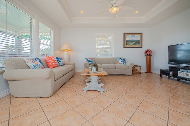 living room with ceiling fan, crown molding, light tile patterned floors, and a raised ceiling