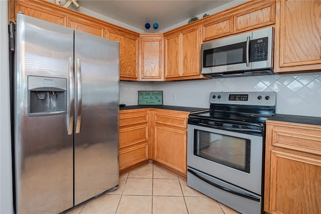 kitchen with stainless steel appliances, light tile patterned floors, and backsplash