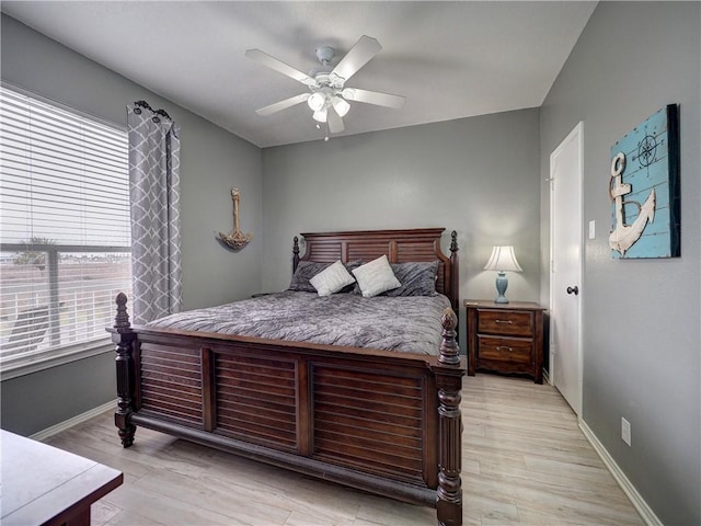 bedroom with ceiling fan, light wood-style flooring, and baseboards