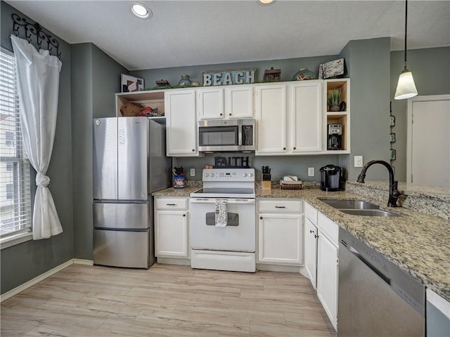 kitchen with white cabinetry, appliances with stainless steel finishes, open shelves, and a sink