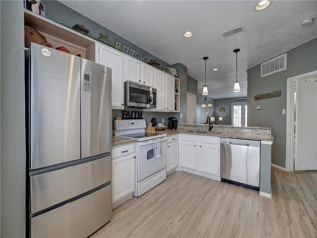 kitchen with open shelves, white cabinetry, appliances with stainless steel finishes, and pendant lighting