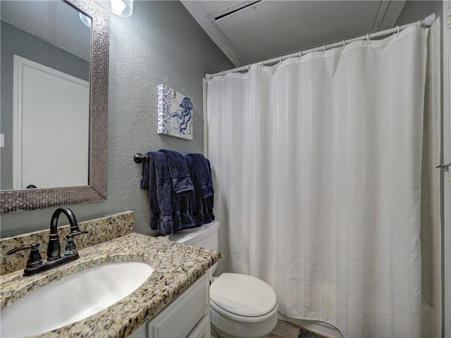 full bath with curtained shower, a textured wall, vanity, and toilet