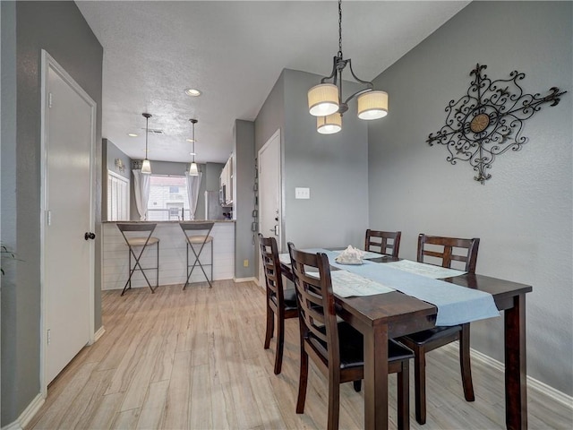 dining room featuring light wood finished floors and baseboards