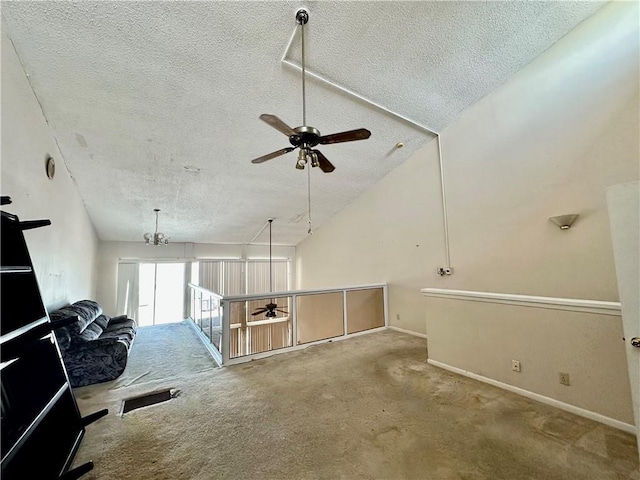 3402 Ocean Dr Unit 8, Corpus Christi, TX 78411 - unfurnished living room featuring a textured ceiling, a ceiling fan, carpet, baseboards, and vaulted ceiling