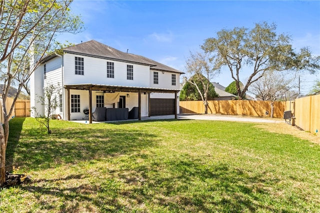 rear view of house with a lawn, driveway, a patio, a fenced backyard, and an attached garage