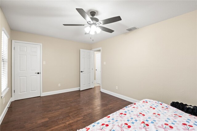 unfurnished bedroom featuring visible vents, multiple windows, baseboards, and wood finished floors