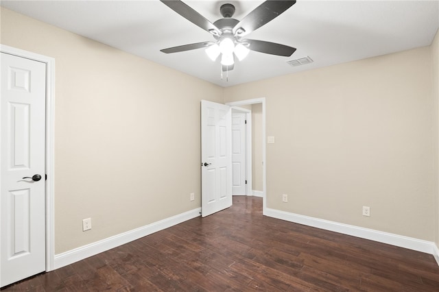 unfurnished room featuring visible vents, baseboards, a ceiling fan, and dark wood-style flooring