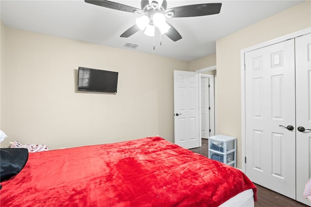 bedroom featuring visible vents, a closet, dark wood finished floors, and a ceiling fan