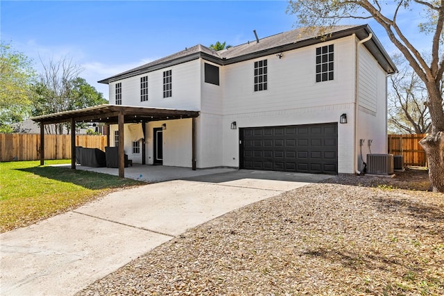 view of front of home with central air condition unit, an attached garage, concrete driveway, and fence