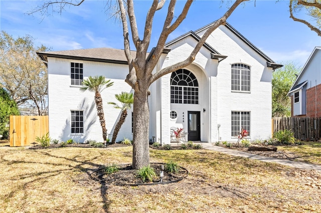 view of front of house with brick siding and fence