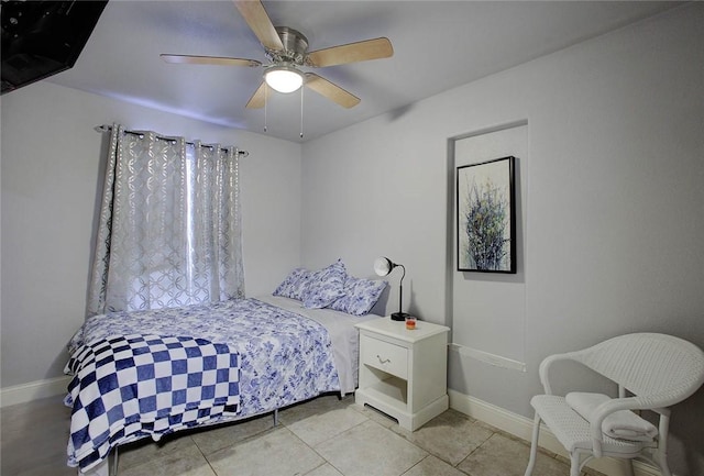 tiled bedroom featuring ceiling fan