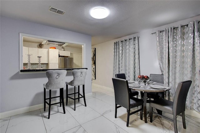 dining space featuring a textured ceiling