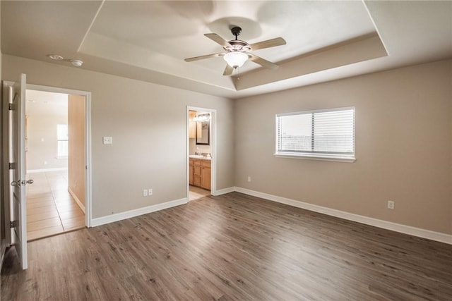 4376 Summer Wind Dr, Corpus Christi, TX 78413 - unfurnished bedroom featuring a tray ceiling, wood finished floors, ensuite bath, and ceiling fan