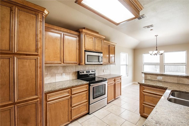 4376 Summer Wind Dr, Corpus Christi, TX 78413 - kitchen with stainless steel appliances, tasteful backsplash, light tile patterned flooring, vaulted ceiling, and brown cabinetry