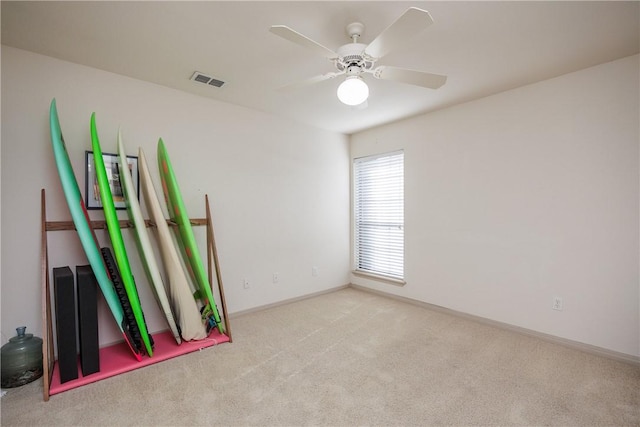 unfurnished room featuring baseboards, ceiling fan, visible vents, and light colored carpet