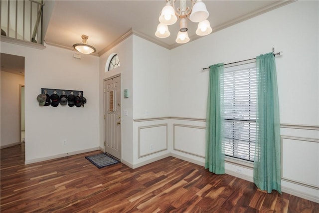 foyer entrance with ornamental molding, a chandelier, and dark hardwood / wood-style flooring