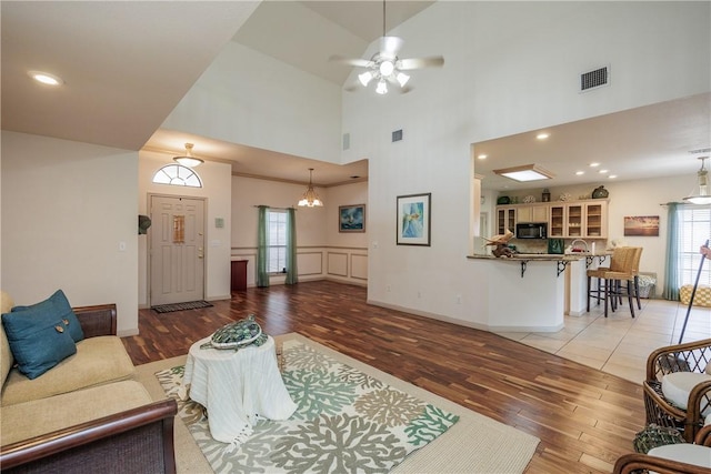 living room featuring ceiling fan, wood-type flooring, and high vaulted ceiling