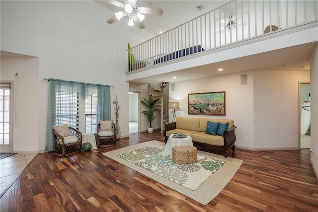 living area with baseboards, visible vents, dark wood finished floors, and a wealth of natural light