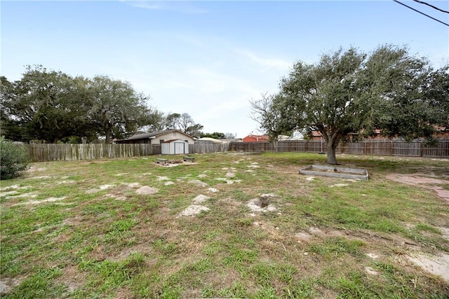 view of yard featuring a fenced backyard, an outdoor structure, and a storage unit