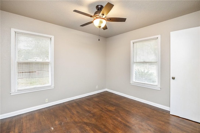 empty room with dark wood-style floors, a textured ceiling, baseboards, and a ceiling fan