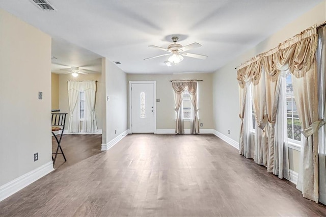 interior space featuring visible vents, baseboards, wood finished floors, and a ceiling fan