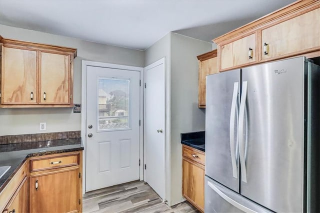 kitchen with dark countertops, light wood-type flooring, and freestanding refrigerator