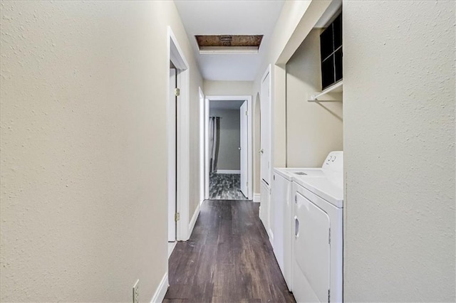 corridor featuring baseboards, dark wood-style flooring, a textured wall, and washer and clothes dryer