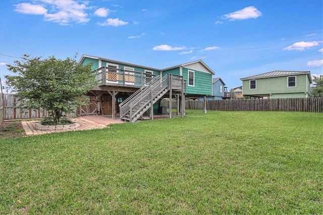 rear view of property featuring stairway, a wooden deck, a yard, a fenced backyard, and a patio