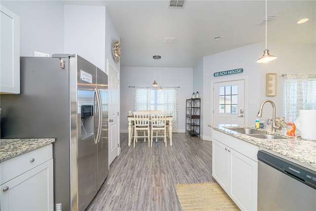 kitchen with wood-type flooring, white cabinetry, sink, and appliances with stainless steel finishes