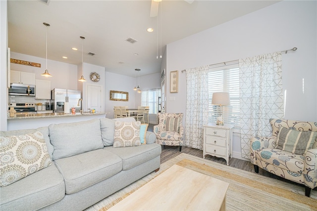 living room featuring light hardwood / wood-style floors and ceiling fan