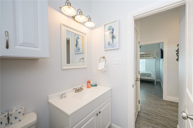 bathroom featuring toilet, vanity, and wood-type flooring