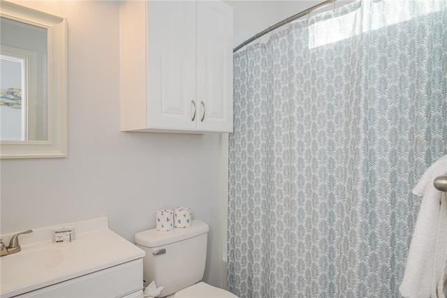 bathroom with toilet, vanity, and a shower with shower curtain