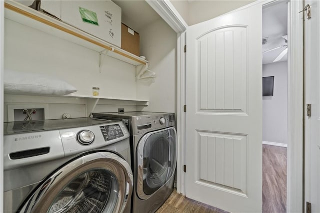 clothes washing area featuring washing machine and clothes dryer and dark hardwood / wood-style flooring